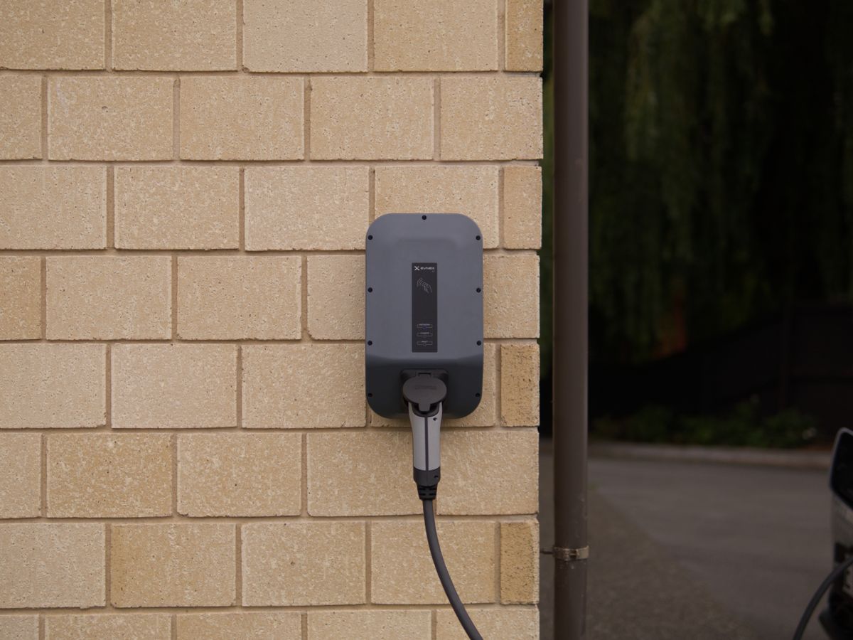 Wall-mounted Level 2 EV charger with cable concealed in a neat conduit run